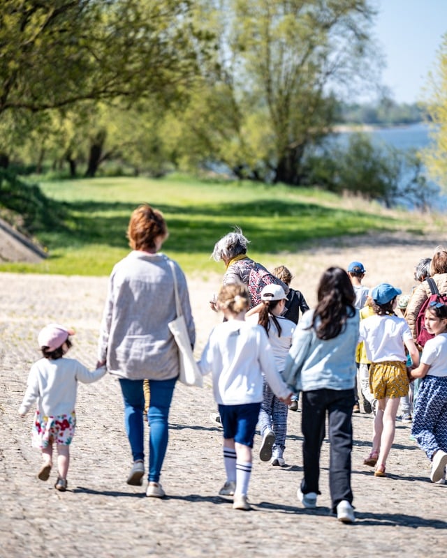 Groupe d'enfants marchants accompagnés d'adultes